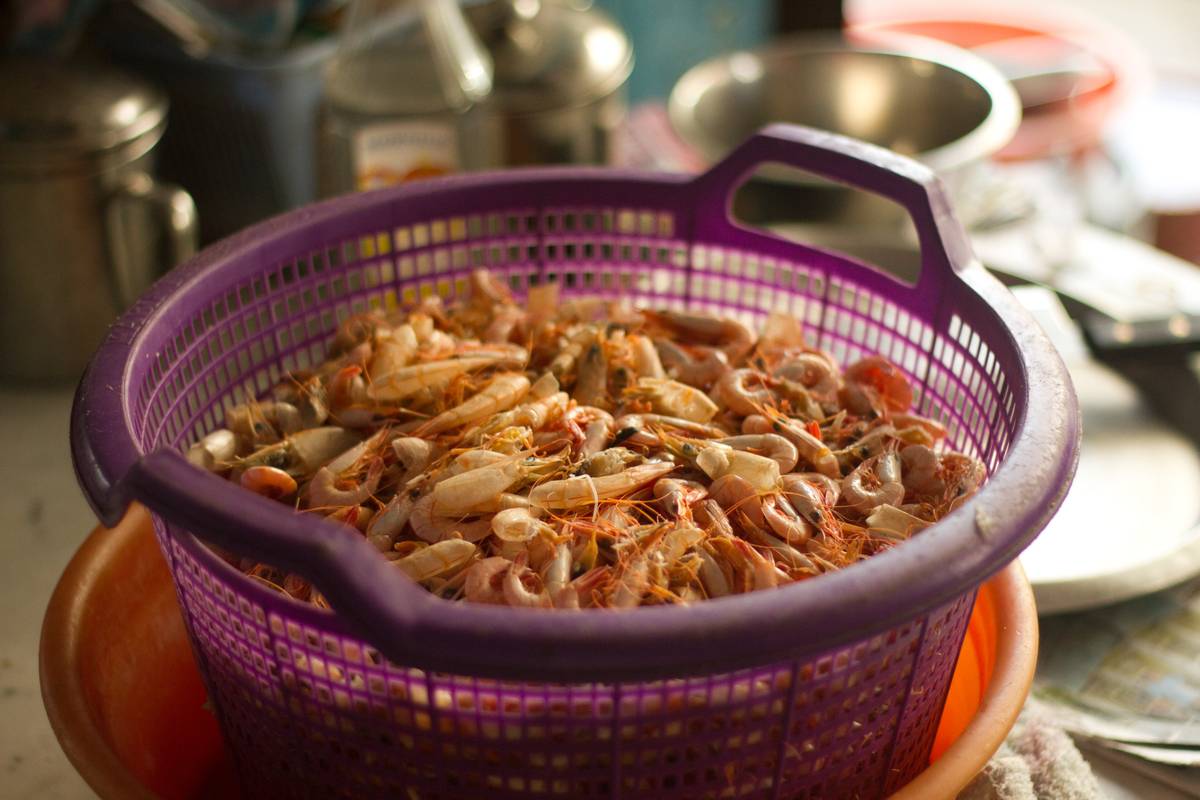 A basket of shrimp shells being prepared to become the soup base for the prawn noodle soup.