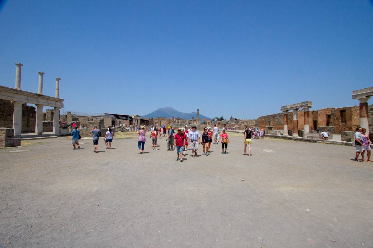 The Roman forum at the center of Pompeii with Vesuvius, the volcano that destroyed this very city, in the background