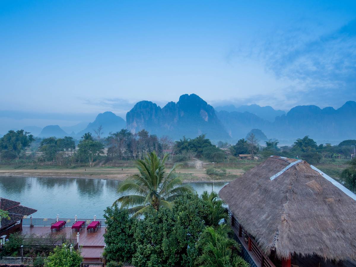 Vang Vieng. It's a beautiful town and I stayed at one of the best hotel rooms, but I had a piercing pain stomachache. I missed the sunset, though I managed to capture this serene dawn scene.