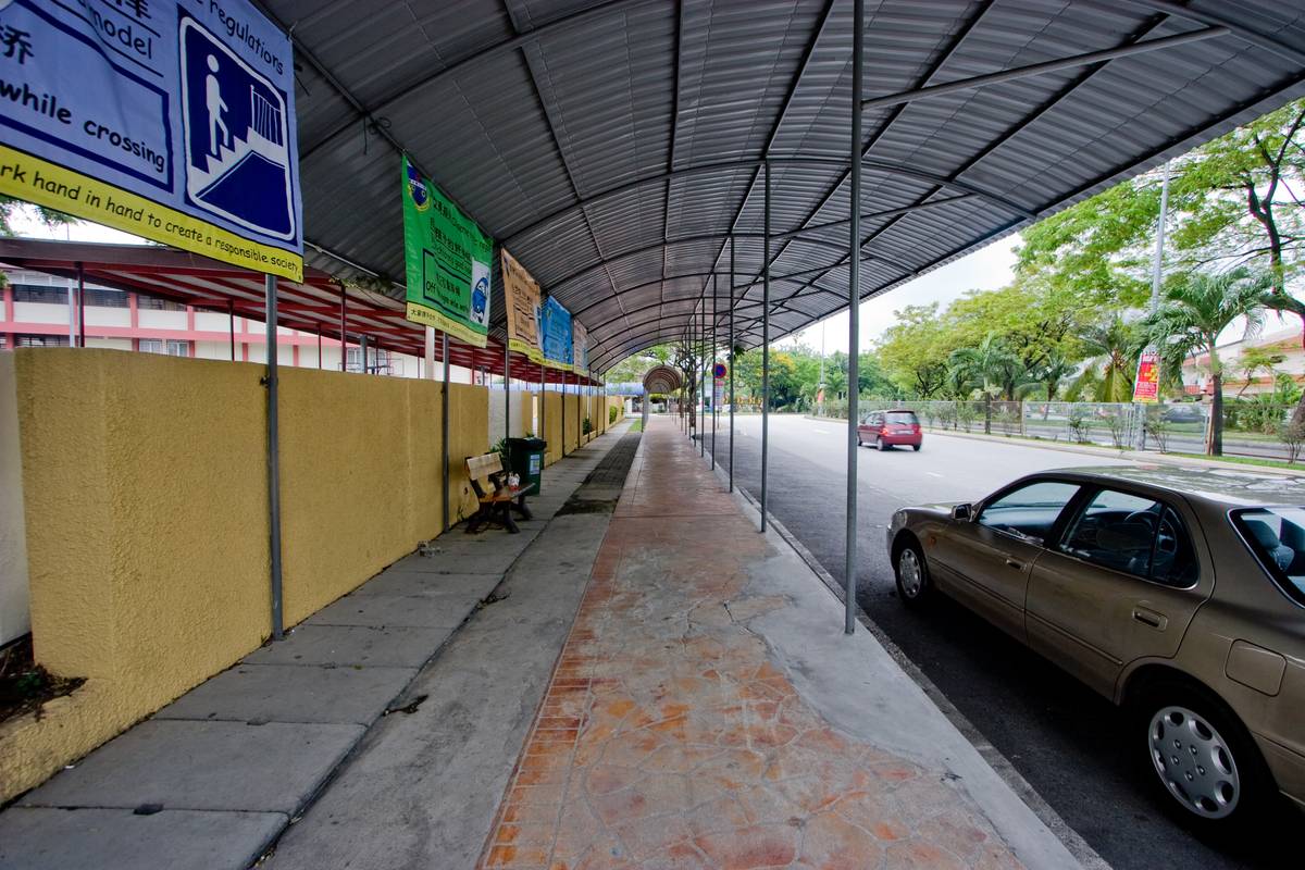 A roofed area for pick up and drop off of students runs from the front to the rear entrances of the school.