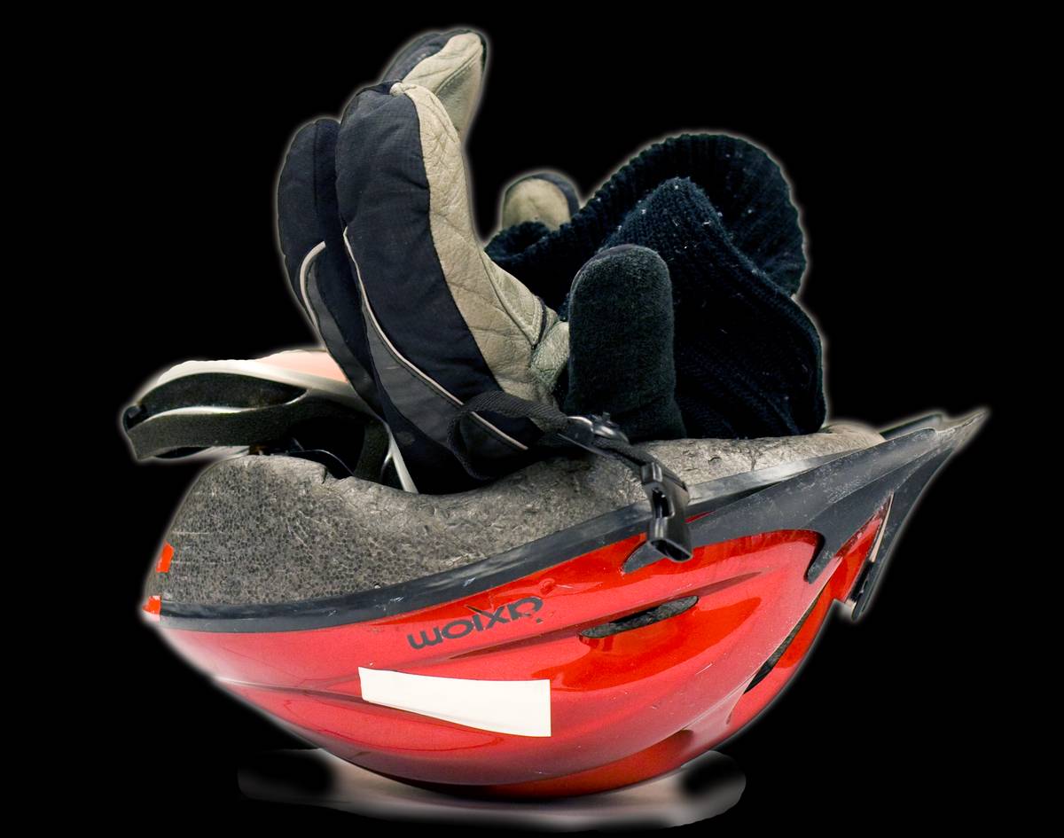 Ski goggles, balaclava and lobster mitts stuck into a helmet