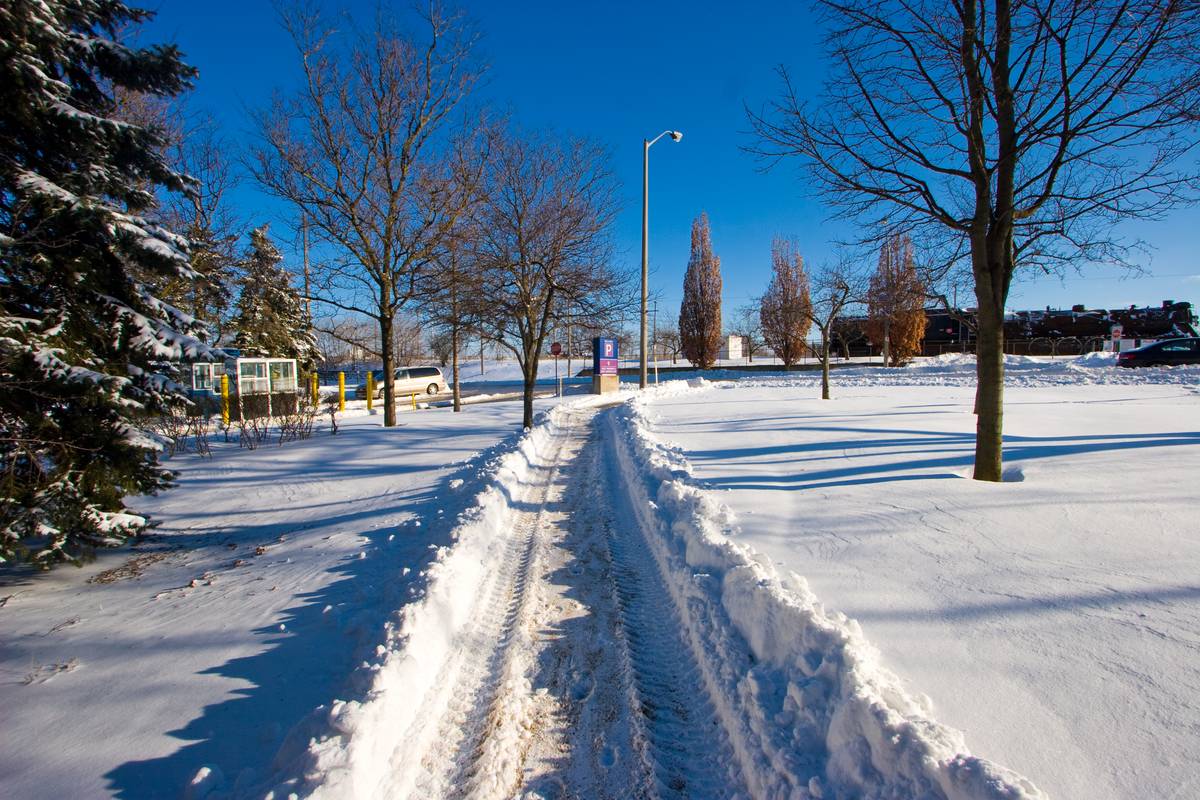 Very heavy snow leading out of the East Parkade parking lot in Guelph, a narrow path carved out by the snow plow