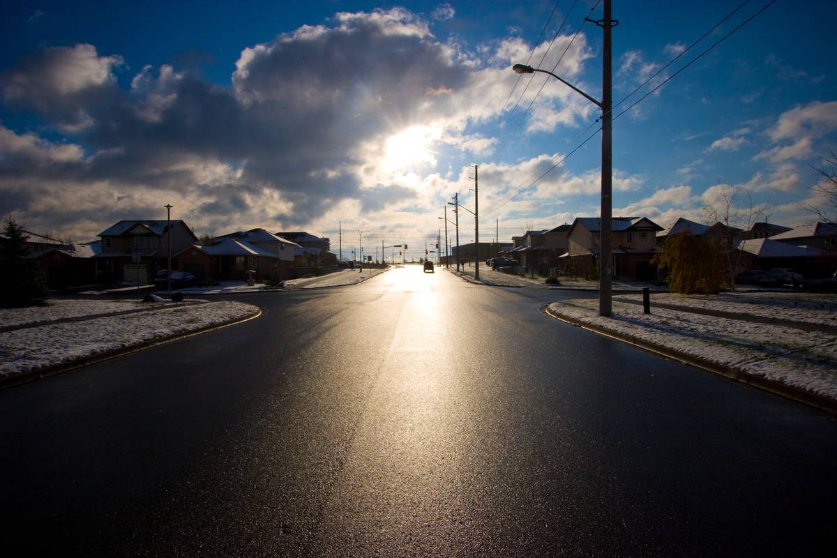 Snowfall left grass patches in white, and the road a glossy black