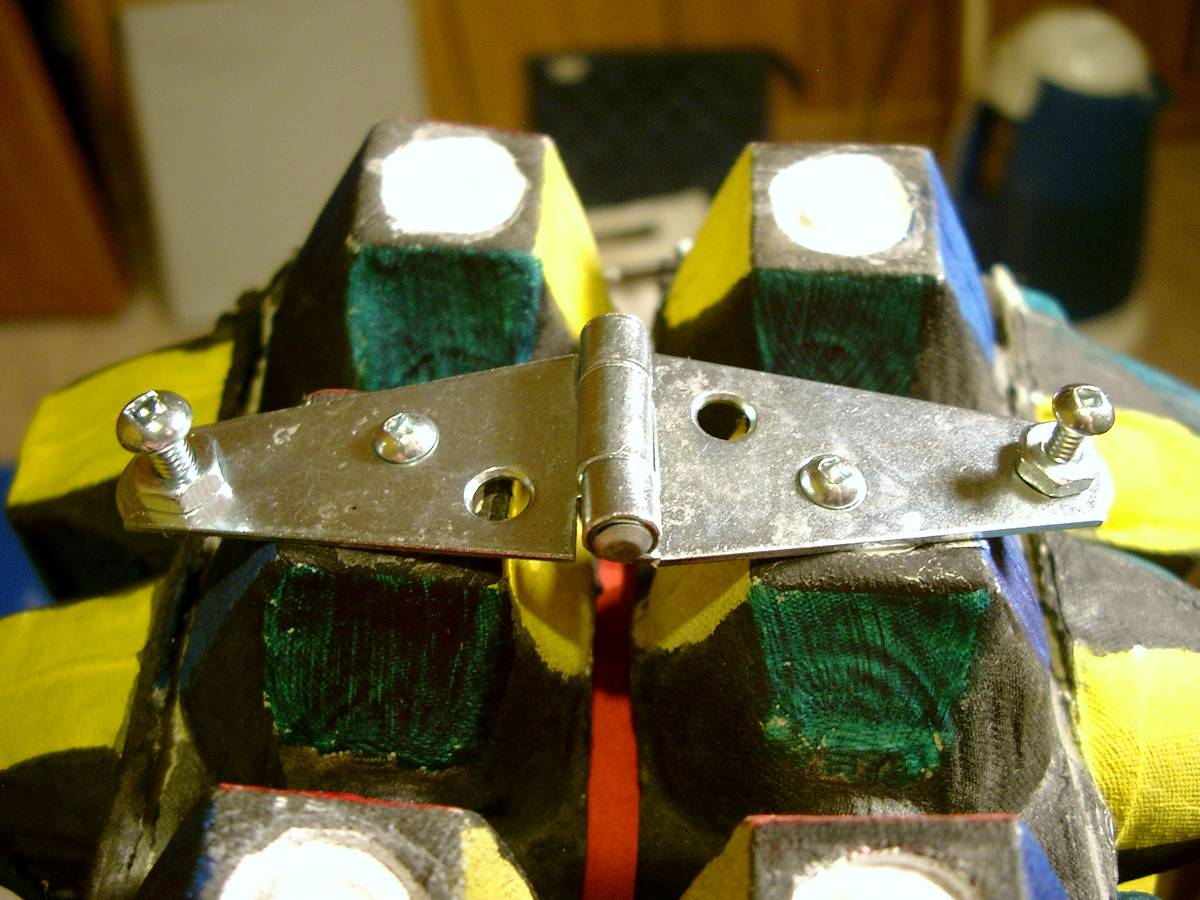 Two hinges hold the suitcase panels together, allowing them to open freely. Bolts hold the hinges onto the egg trays