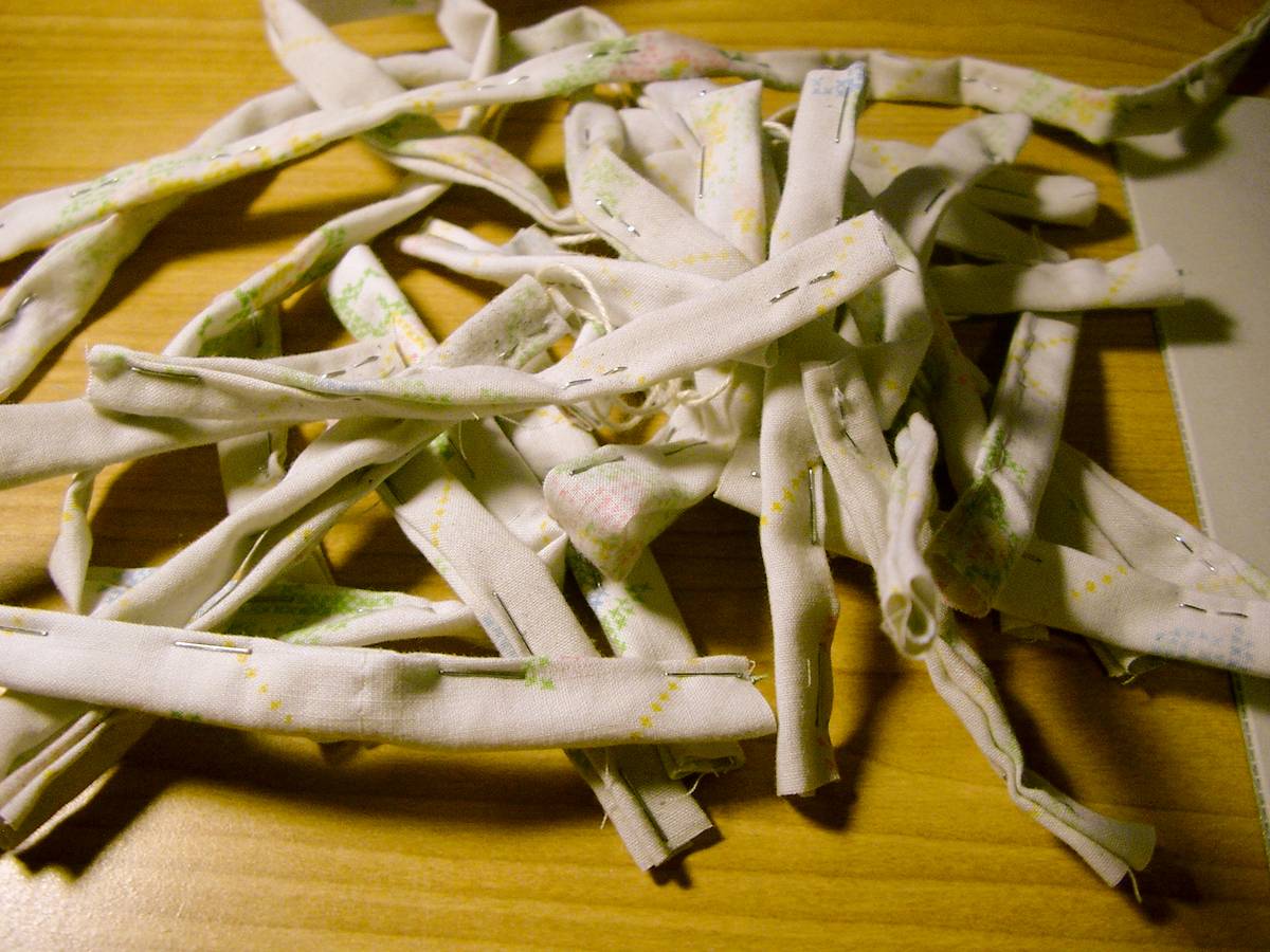 Stack of 22 quadruple-layered cloths stapled. This will form the hooks for adjusting the lid tension. Sewing them together is one alternative, but more time consuming than stapling