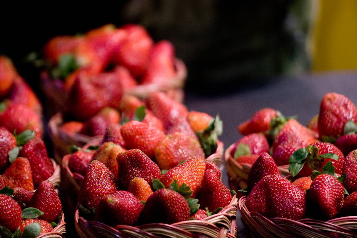 Strawberries for sale in the market, at $1 for each basket.