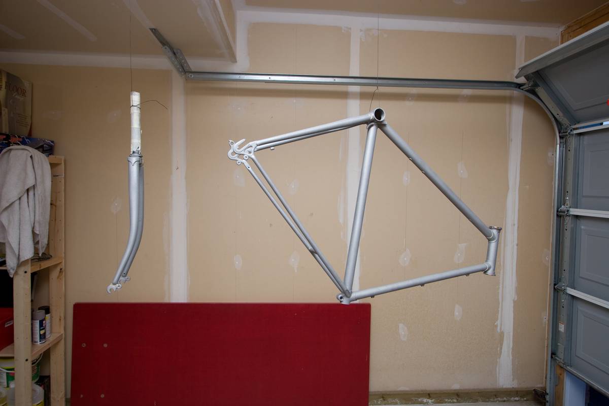 Two main parts of a bicycle – the frame and the fork – hung and ready for painting